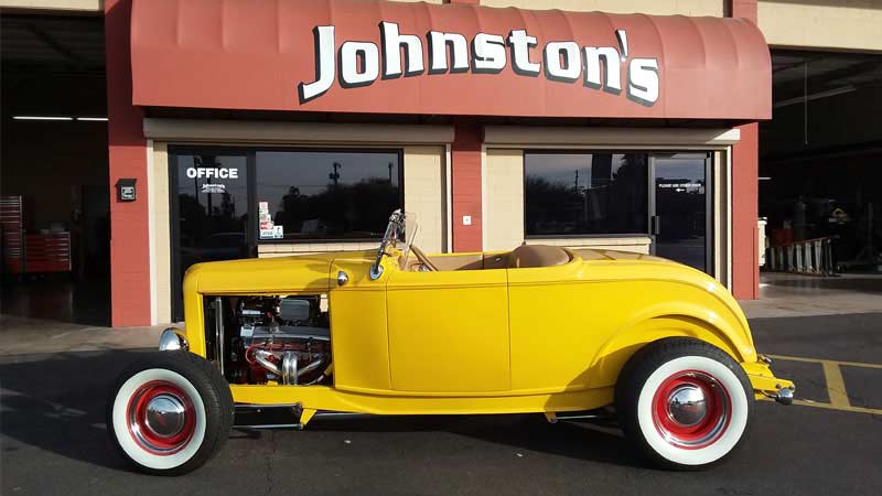 Yellow roadster outside Johnston's Automotive storefront